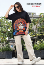 Woman wearing a black t-shirt with a colorful graphic design outdoors.